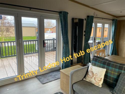 a living room with a sliding glass door at Trinity lodge hot tub escapes at Tattershall lakes in Tattershall