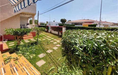a garden with a bench and plants and a house at Cozy Apartment In Vinaroz With Kitchen in Vinaròs