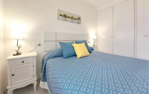 a bedroom with a bed with blue and yellow pillows at Cozy Apartment In Vinaroz With Kitchen in Vinarós