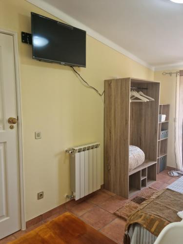 um quarto com uma televisão de ecrã plano na parede em Casa Anjos em Coimbra