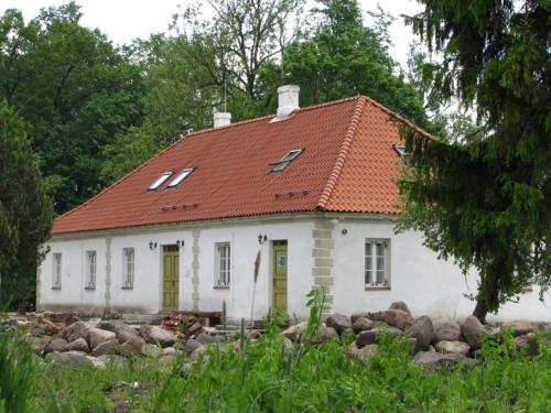 a small white house with a red roof at Torma Puhkemaja ja Glämping in Torma