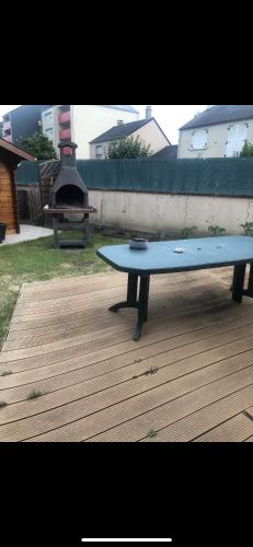 une table bleue assise au-dessus d'une terrasse en bois dans l'établissement Maison entière, au Mans