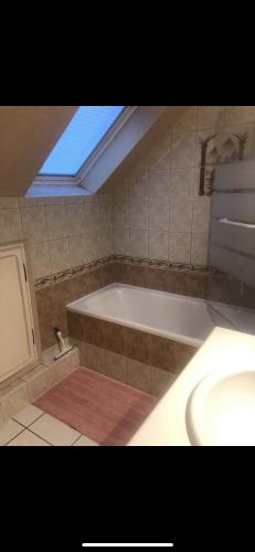 une salle de bain avec une baignoire et un lavabo dans l'établissement Maison entière, au Mans