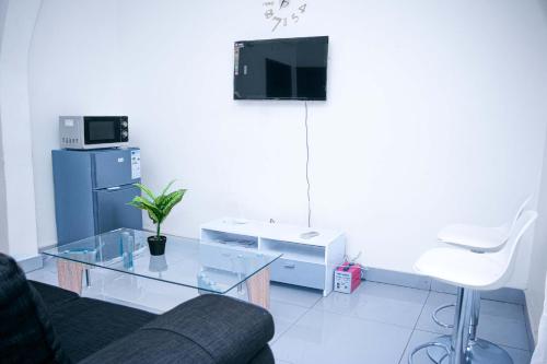 Télévision ou salle de divertissement dans l'établissement NAIVELI-PALM Appartement meublé sobre et chic