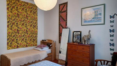 Habitación con cama, tocador y pintura en MAISON DE CHARME AVEC COUR, proche rue des Teinturiers en Aviñón