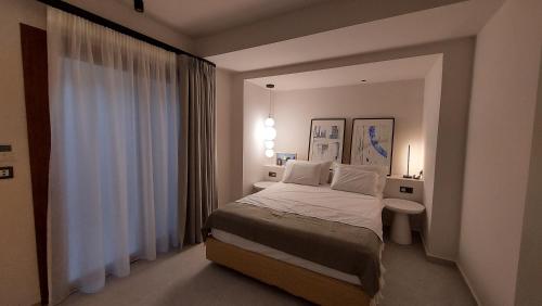 a white bedroom with a bed and a sink at Kynara Elegant Living in Ierissos