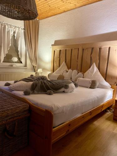 Ferienwohnung Schmidtalien في Dommitzsch: غرفة نوم بسرير خشبي مع شراشف ووسائد بيضاء