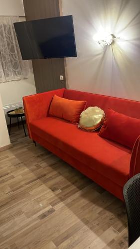 um sofá vermelho com almofadas numa sala de estar em Magnifique appartement 2 pièces em Deauville