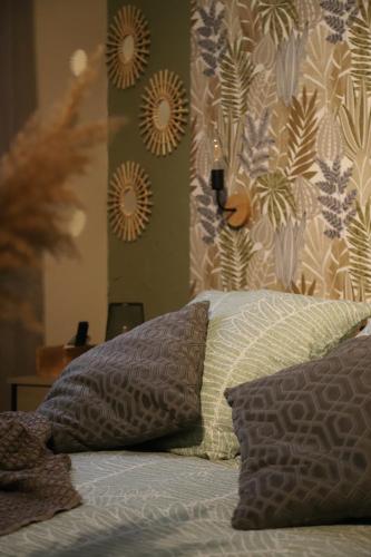 a bedroom with a bed with two pillows on it at Les jardins du Patriarche Hôtel in Agde