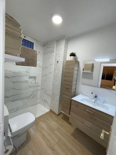 ein weißes Bad mit einem WC und einem Waschbecken in der Unterkunft Blue relax Tabaiba in Tabaiba