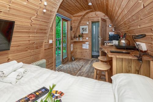 ein Schlafzimmer mit einem Bett in einer Holzhütte in der Unterkunft Nyth Y Goedwig in Dolgellau