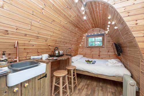 eine kleine Küche mit einem Bett in einem Holzzimmer in der Unterkunft Nyth Y Goedwig in Dolgellau