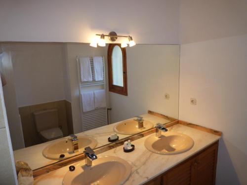 a bathroom with two sinks and a large mirror at private Villa mit eigenem Pool unter Palmen in Cala Llenya