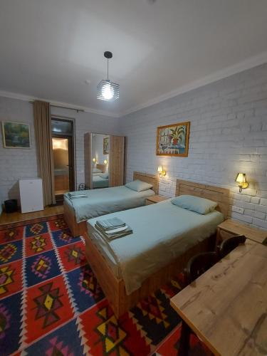 a hotel room with two beds and a rug at MUSAVVIR in Samarkand