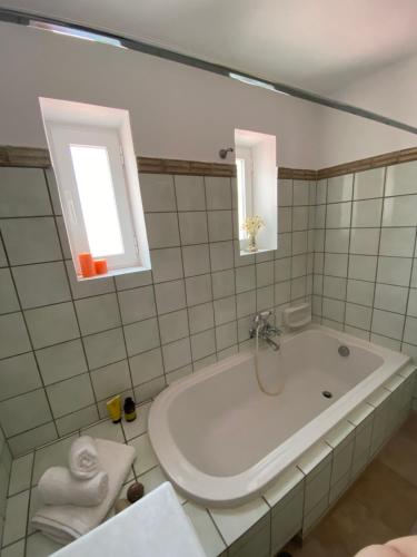 biała łazienka z wanną i oknem w obiekcie sparton amfilohias παραθαλάσσιο εξοχικό Filoxenia w mieście Spárton