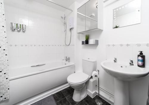 Baño blanco con aseo y lavamanos en Charming 2BR Ground Floor Flat in Sholing, 11 Mins from City Centre - Recently Set Up with Love, en Southampton
