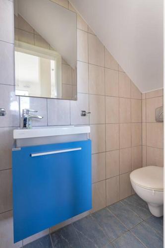 a bathroom with a blue sink and a toilet at Villa Metaxata in Argostoli