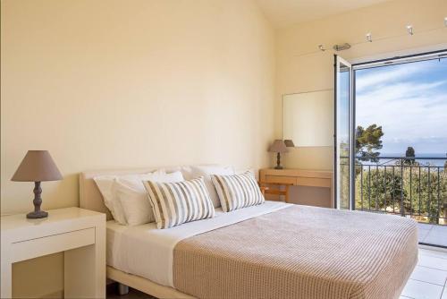 a bedroom with a bed and a view of the ocean at Villa Metaxata in Argostoli