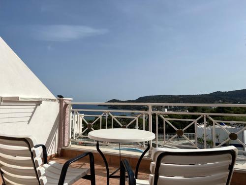 uma varanda com uma mesa e cadeiras e o oceano em Villa Alexandra em Agia Marina