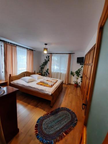 a bedroom with a large bed and a wooden floor at VoroLand in Gura Humorului