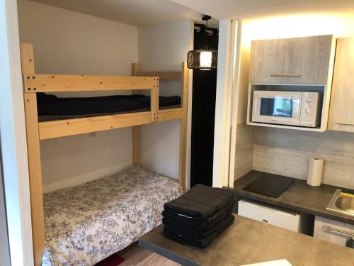 a small room with a bunk bed and a microwave at Studio au pied des sentiers in Villard-de-Lans
