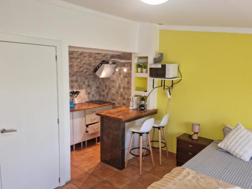 una pequeña cocina con cama y escritorio en una habitación en Casa Anjos, en Coímbra