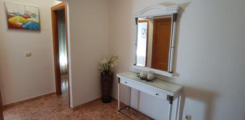 uma casa de banho com um espelho e uma cómoda com um lavatório em Ático en Buenavista playa em Roquetas de Mar