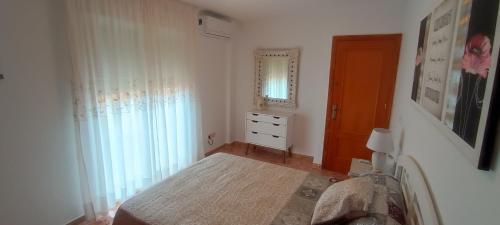 um quarto com uma cama, um espelho e uma porta em Ático en Buenavista playa em Roquetas de Mar
