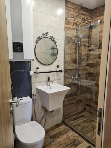 ein Bad mit einem WC, einem Waschbecken und einer Dusche in der Unterkunft Sky flats Varna with parking in Warna
