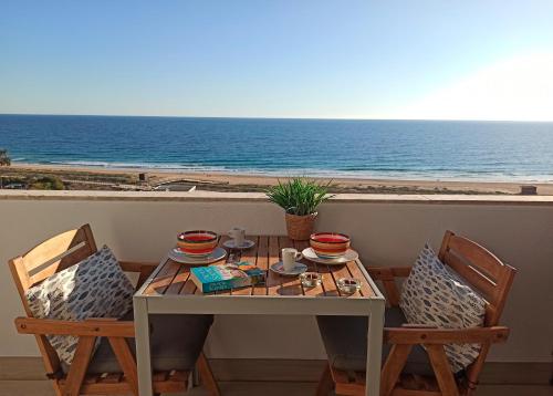 a table and chairs with a view of the ocean at Apart Great Sea View in Alvor