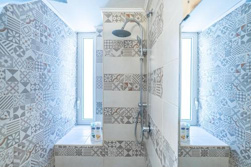 uma casa de banho com chuveiro e azulejos na parede em Casa Vacanze Decumano 18 em Nápoles