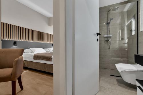 a bedroom with a bed and a bathroom with a shower at Beach Hotel Božikovina in Podstrana