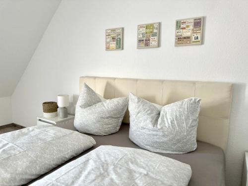Apartment über den Dächern Hamelns في هاملن: اثنين من الوسائد البيضاء تقف على رأس سرير