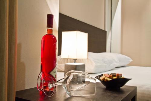 a bottle of wine on a table next to a bed at Apart K Apartments in Belgrade