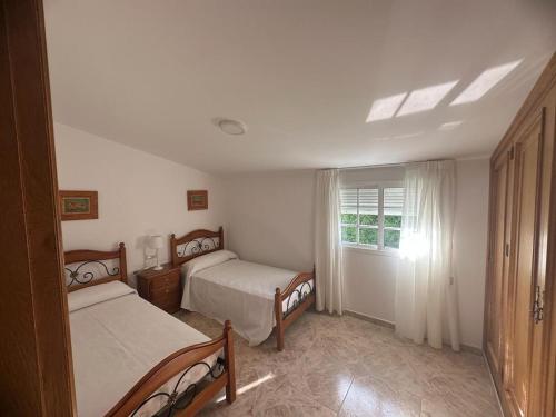 a bedroom with two beds and a window at O Castro Sanxenxo in Sanxenxo