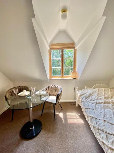 a bedroom with a bed and a table and a window at Zamkowa 4 in Lubniewice