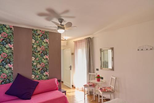 een woonkamer met een roze bank en een tafel bij Dolce Lago B&B in San Felice del Benaco