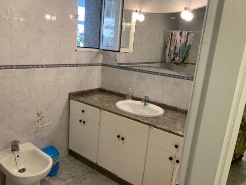 a bathroom with a sink and a mirror and a toilet at Casa Tía María 2 in Villanueva de Arosa