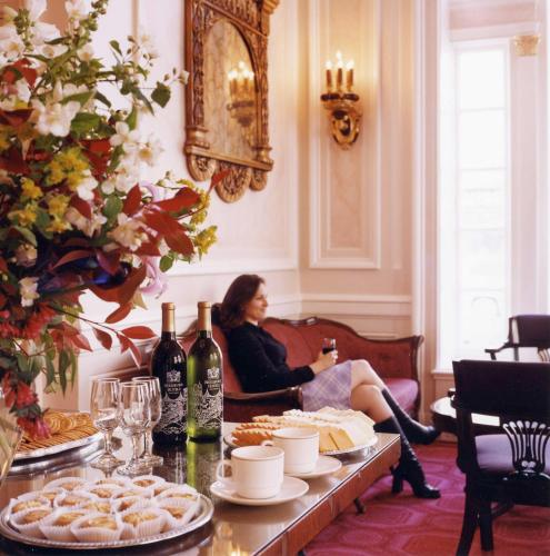 a woman sitting on a couch in a room with a table of food at Beresford Arms in San Francisco