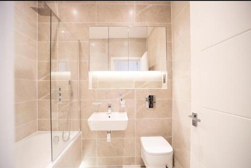 a bathroom with a toilet and a sink and a shower at Two bedrooms, two bath, up to 3 beds 1 sofa - Slough Windsor Legoland in Slough