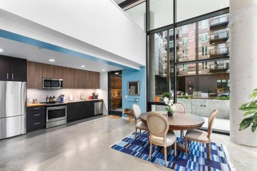 a kitchen with a table and chairs and a large window at Airy and Open Corner Loft - 92 Walkscore in Redmond