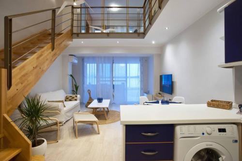 a kitchen and living room with a staircase and a washer at Seagull Luxury Maisonette in Itea