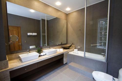 a bathroom with two sinks and a large mirror at Casa Bueras Boutique Hotel in Santiago
