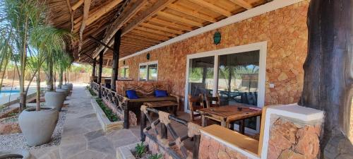 a patio with wooden tables and chairs on a building at Salama & Mbuyuni Bungalows in Matemwe