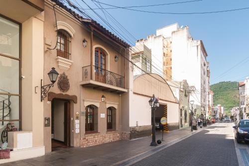 a city street with buildings and a car parked on the street at Hotel Boutique Balcón de la Plaza in Salta