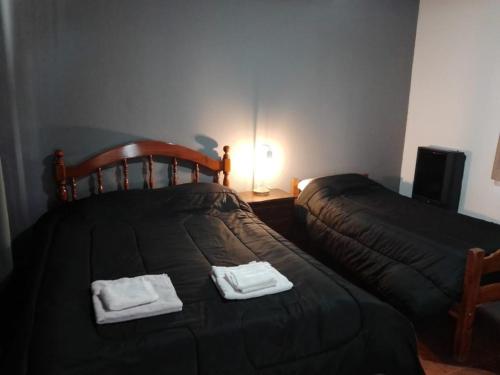 ein Schlafzimmer mit einem Bett mit zwei Handtüchern darauf in der Unterkunft Departamentos alvear in Esquel