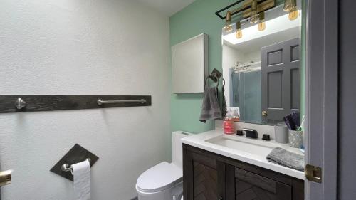 a bathroom with a sink and a toilet and a mirror at Spacious, Cheerful, Modern Home 5 BR, 3BA, 2KIT in Shoreline