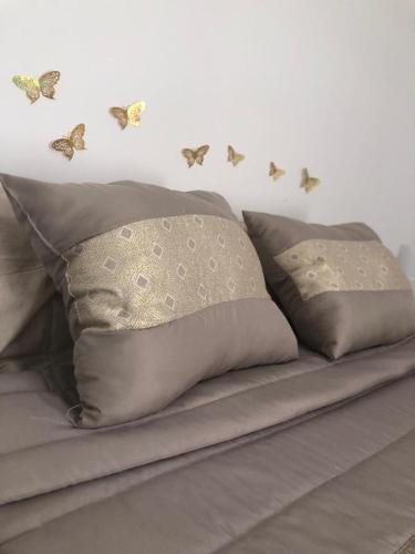 uma cama com borboletas numa parede branca em Casa Da Praça em São Pedro do Corval