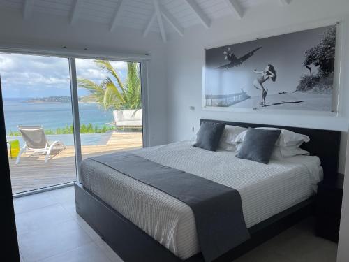 The Red Cloud 3 في Saint Barthelemy: غرفة نوم مع سرير وإطلالة على المحيط