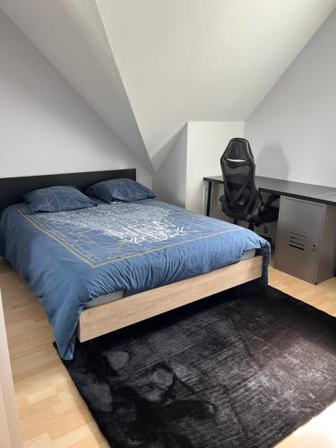 1 dormitorio con cama, escritorio y silla en Chambre, en Roézé-sur-Sarthe